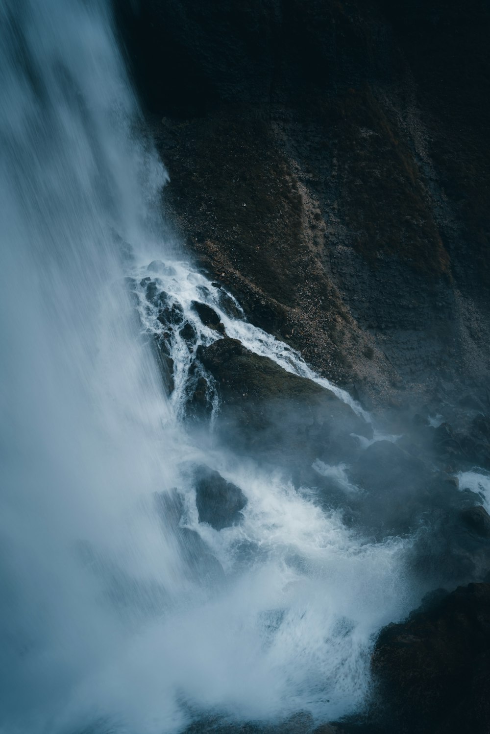 water falls on brown rocky mountain