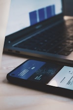 black android smartphone beside black laptop computer