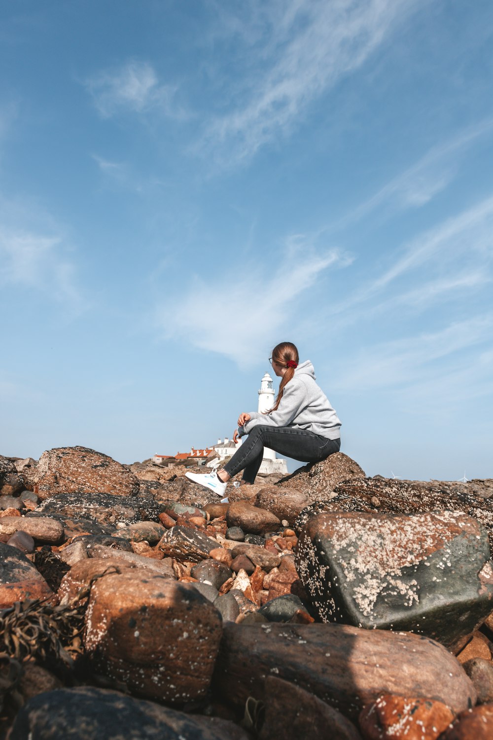 man in white dress shirt sitting on rock during daytime