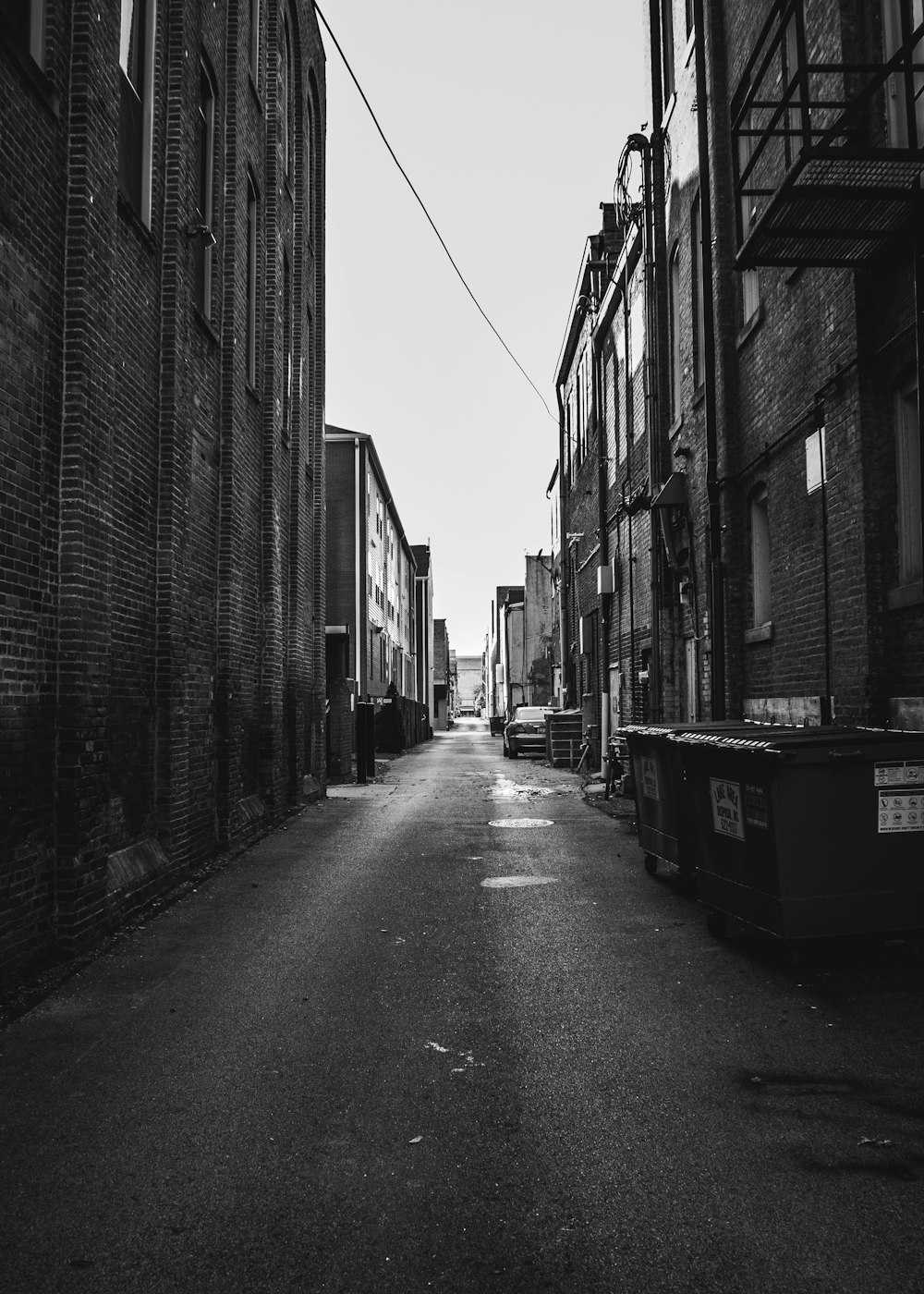 grayscale photo of empty street between buildings