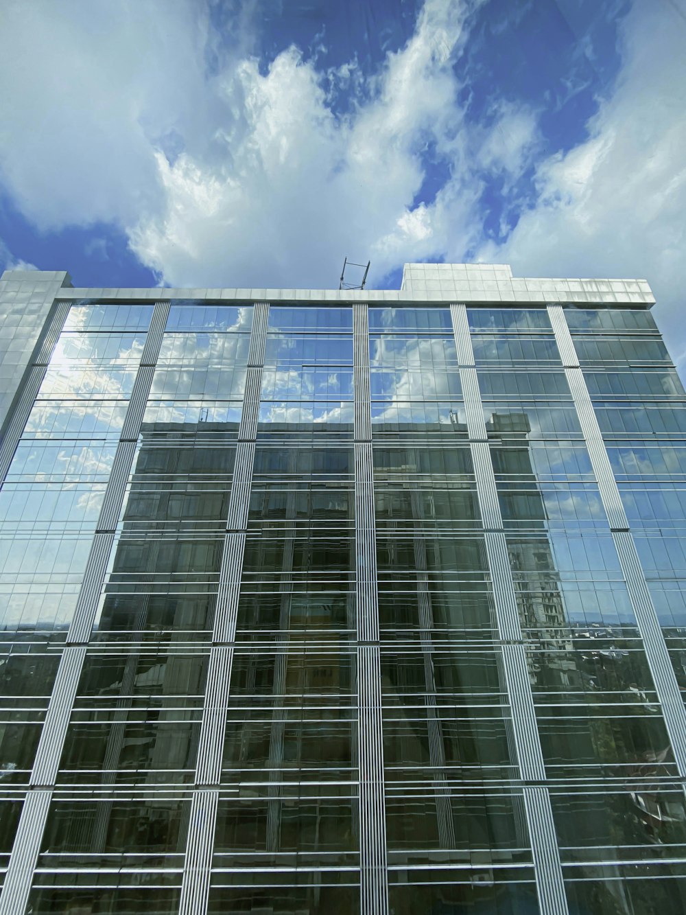 white clouds over glass building