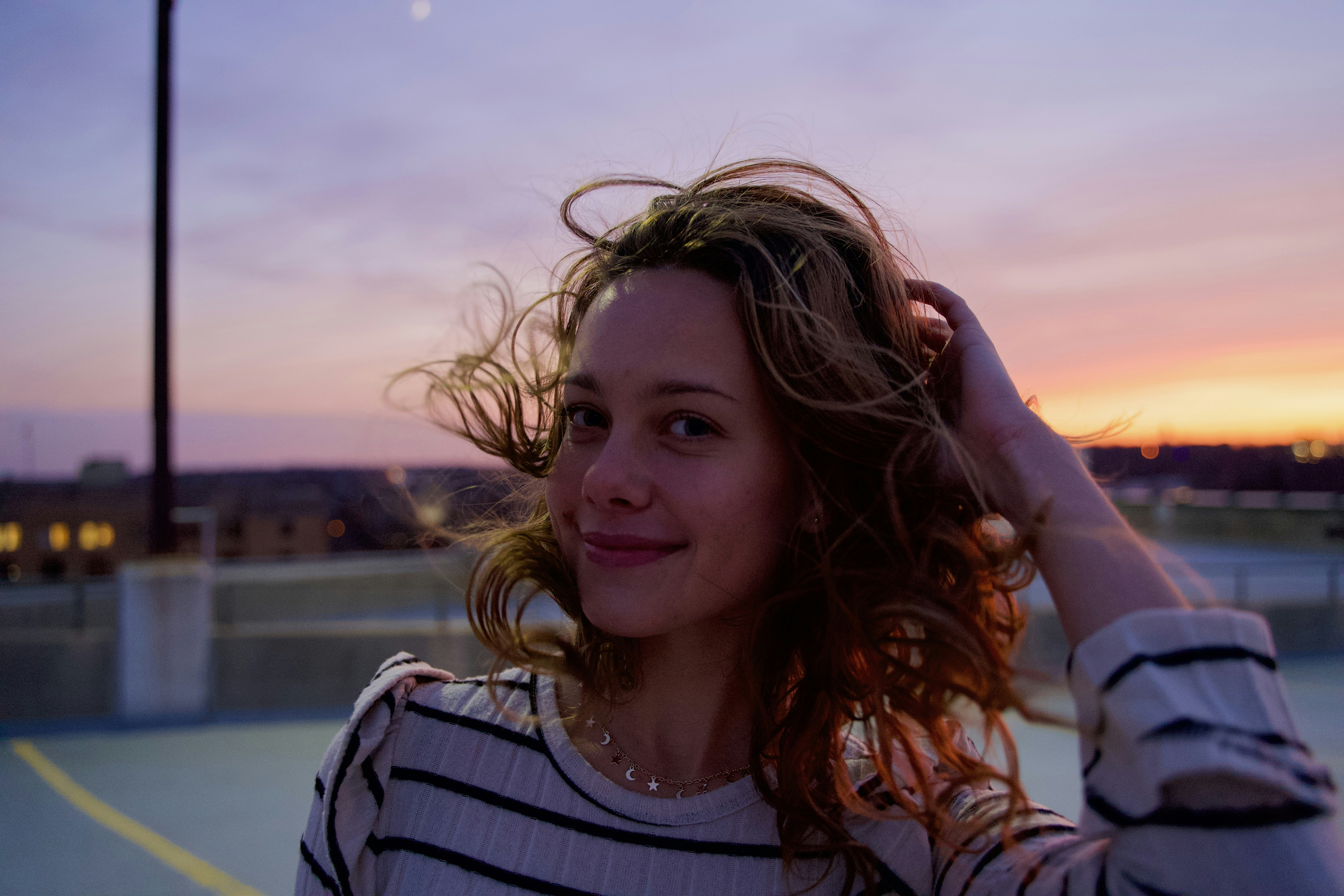 girl in white and black stripe tank top smiling