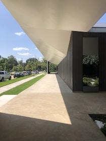 A contemporary tensile shade structure casting smooth shadows over a parking lot.