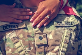 person wearing silver ring and green and beige camouflage pants