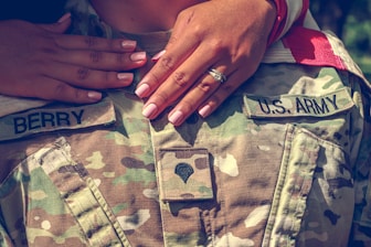 person wearing silver ring and green and beige camouflage pants
