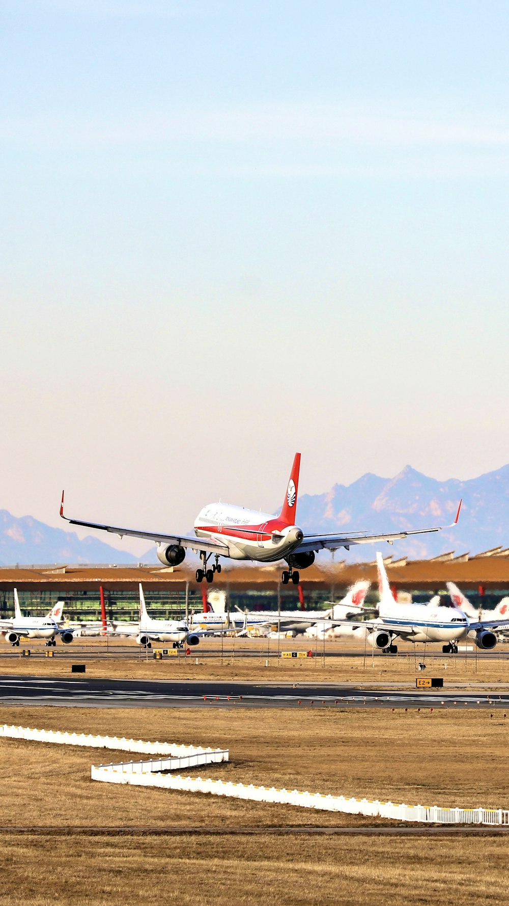 white and red airplane on airport during daytime