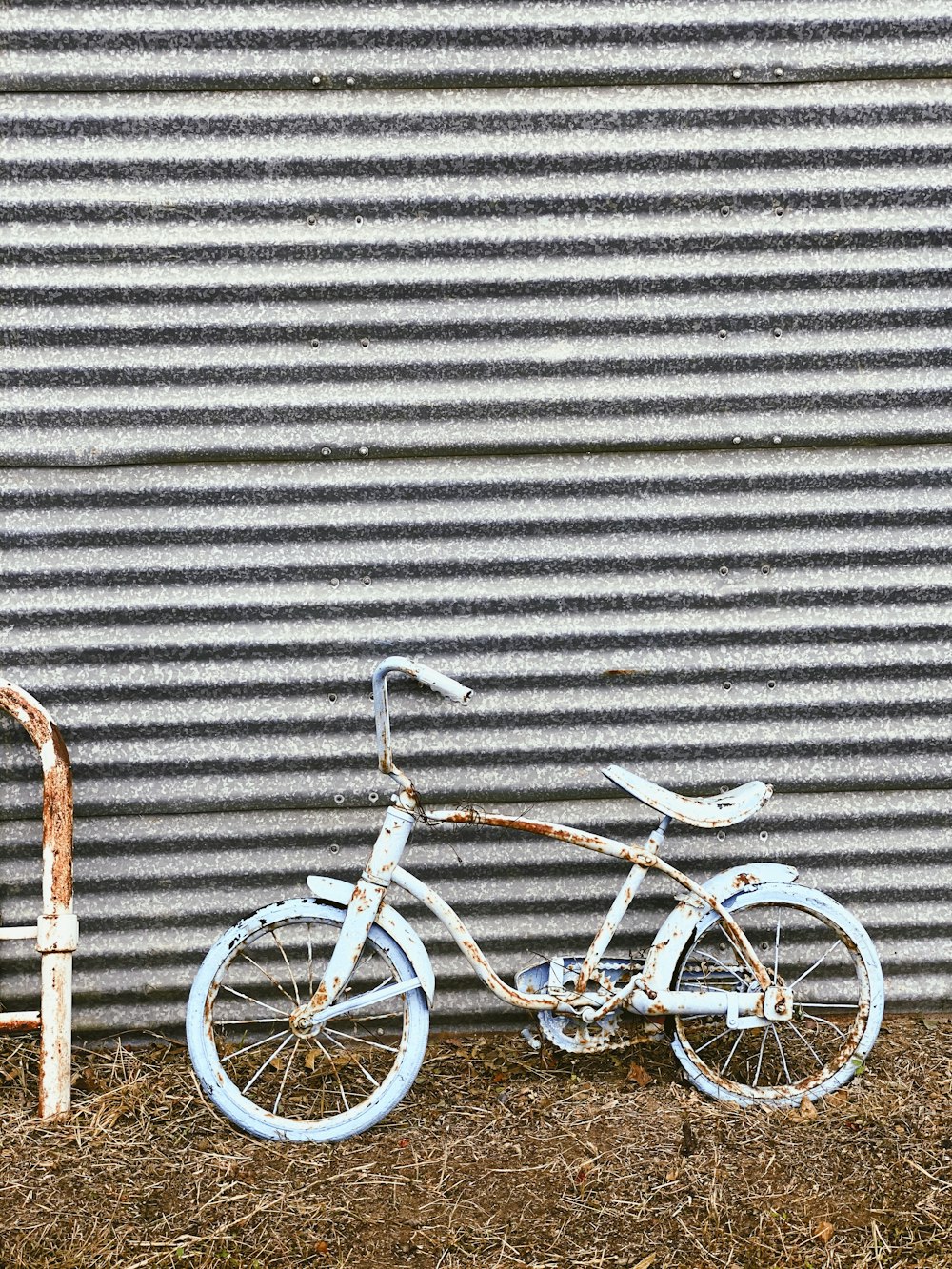 white city bike leaning on gray wall