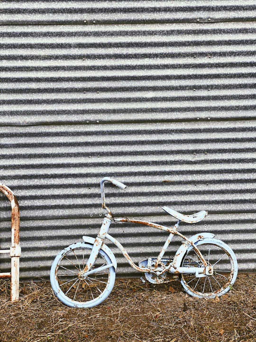 white city bike leaning on gray wall