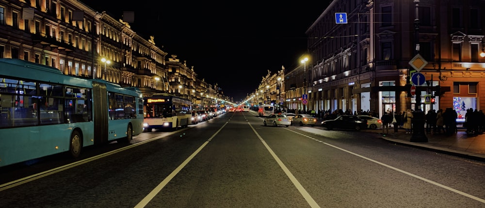 cars on road between buildings during night time