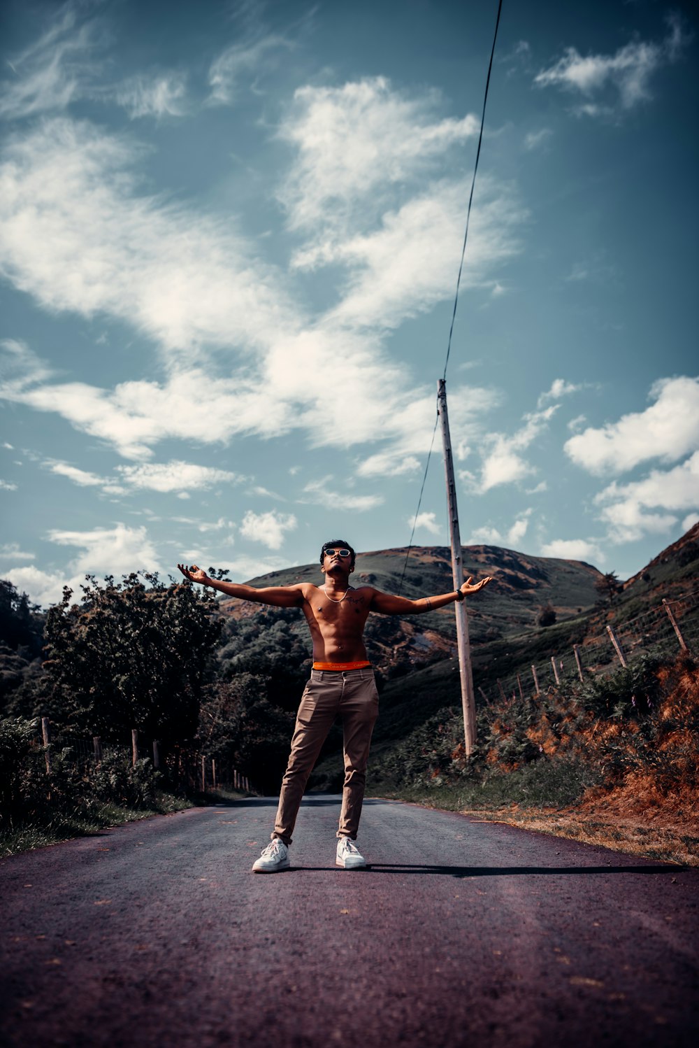 woman in brown tank top and white pants holding rope during daytime