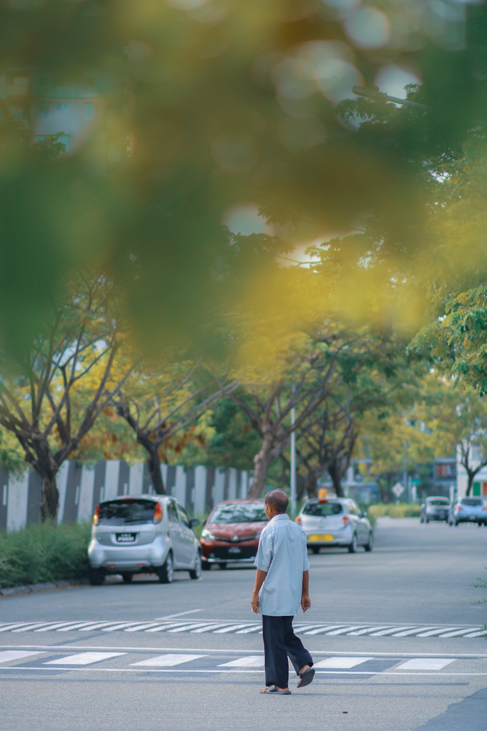 man in white dress shirt walking on sidewalk during daytime