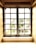 A vintage-style window featuring multiple panes is framed by light beige walls. Natural light filters through the slightly weathered glass, revealing a blurred view of greenery outside. The windowsill appears aged, with subtle signs of wear.