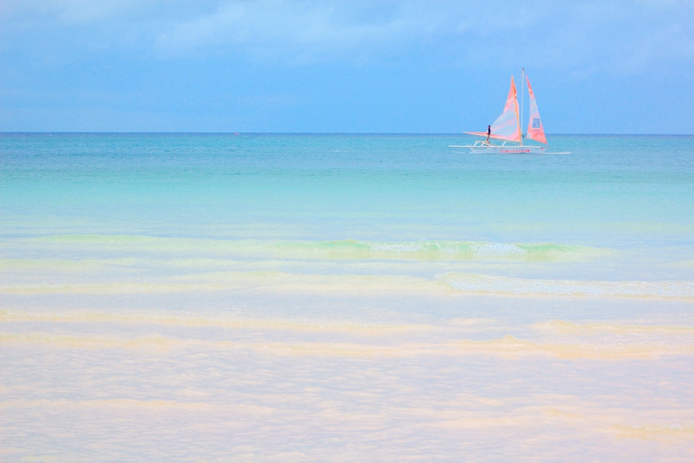 white sail boat on sea during daytime