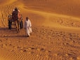 man and woman walking on desert during daytime