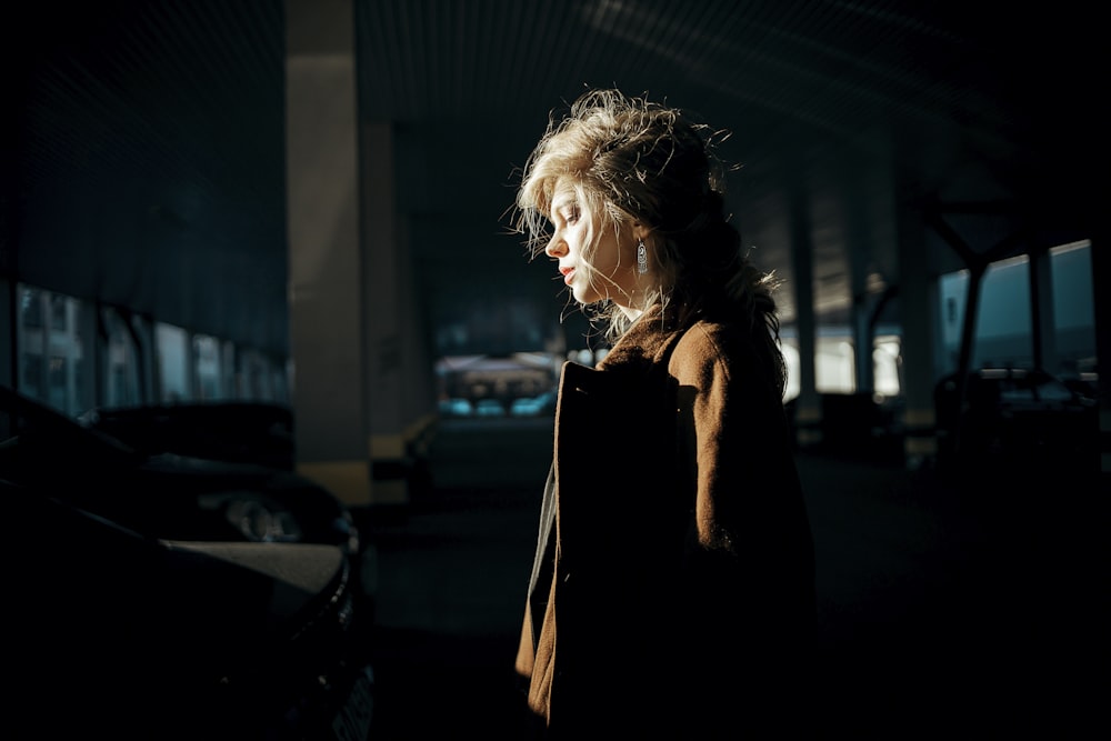 a woman standing in a parking lot at night