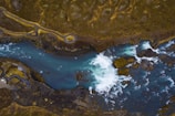 Dynamic aerial perspective of a winding river cutting through raw nature.