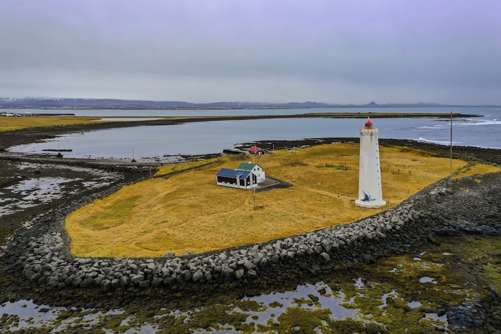 blue and white car on road near lighthouse during daytime