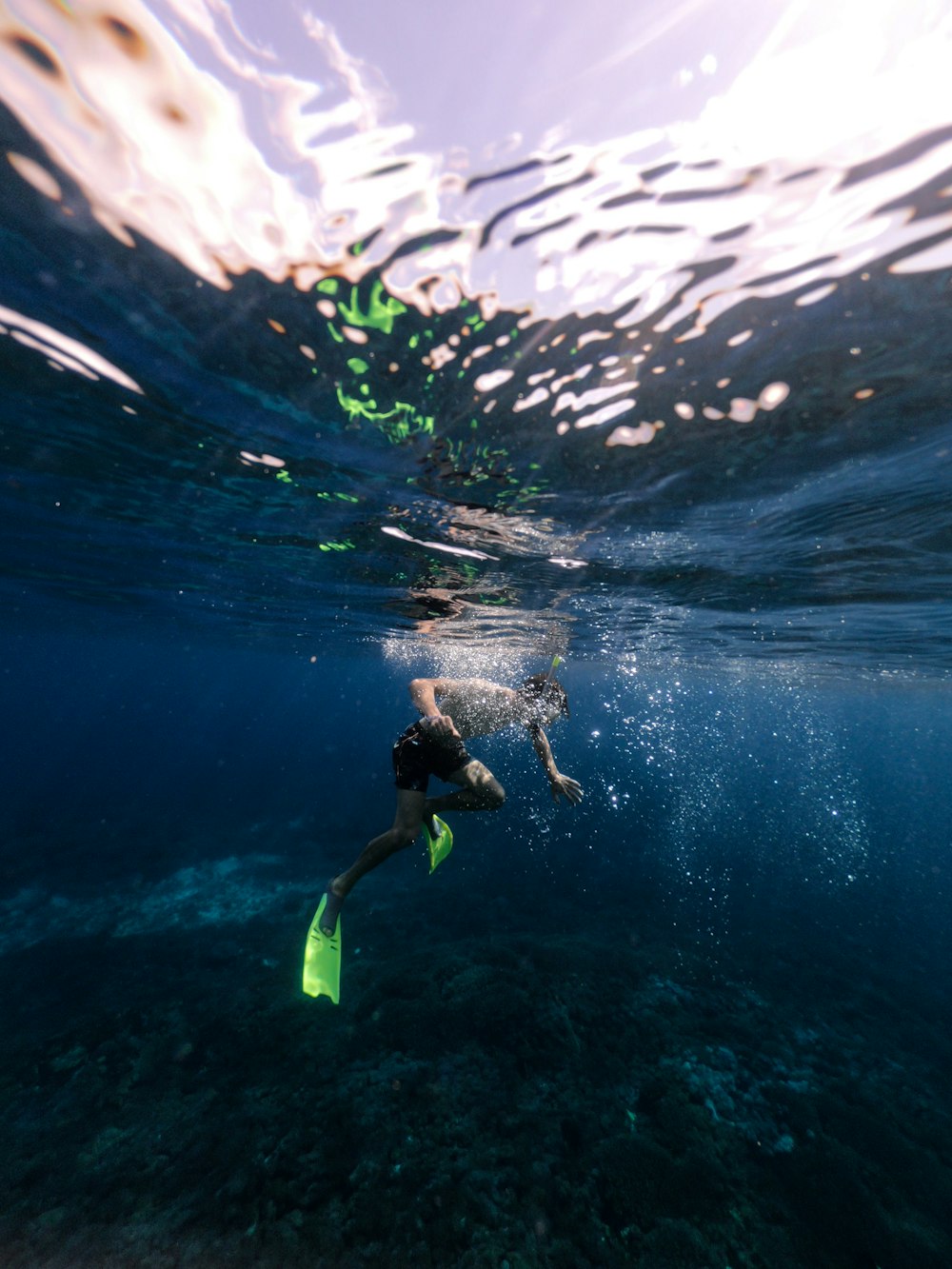 person in black wet suit under water