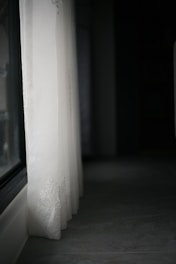 close-up of delicate, flowing white curtains filtering sunlight in a serene room