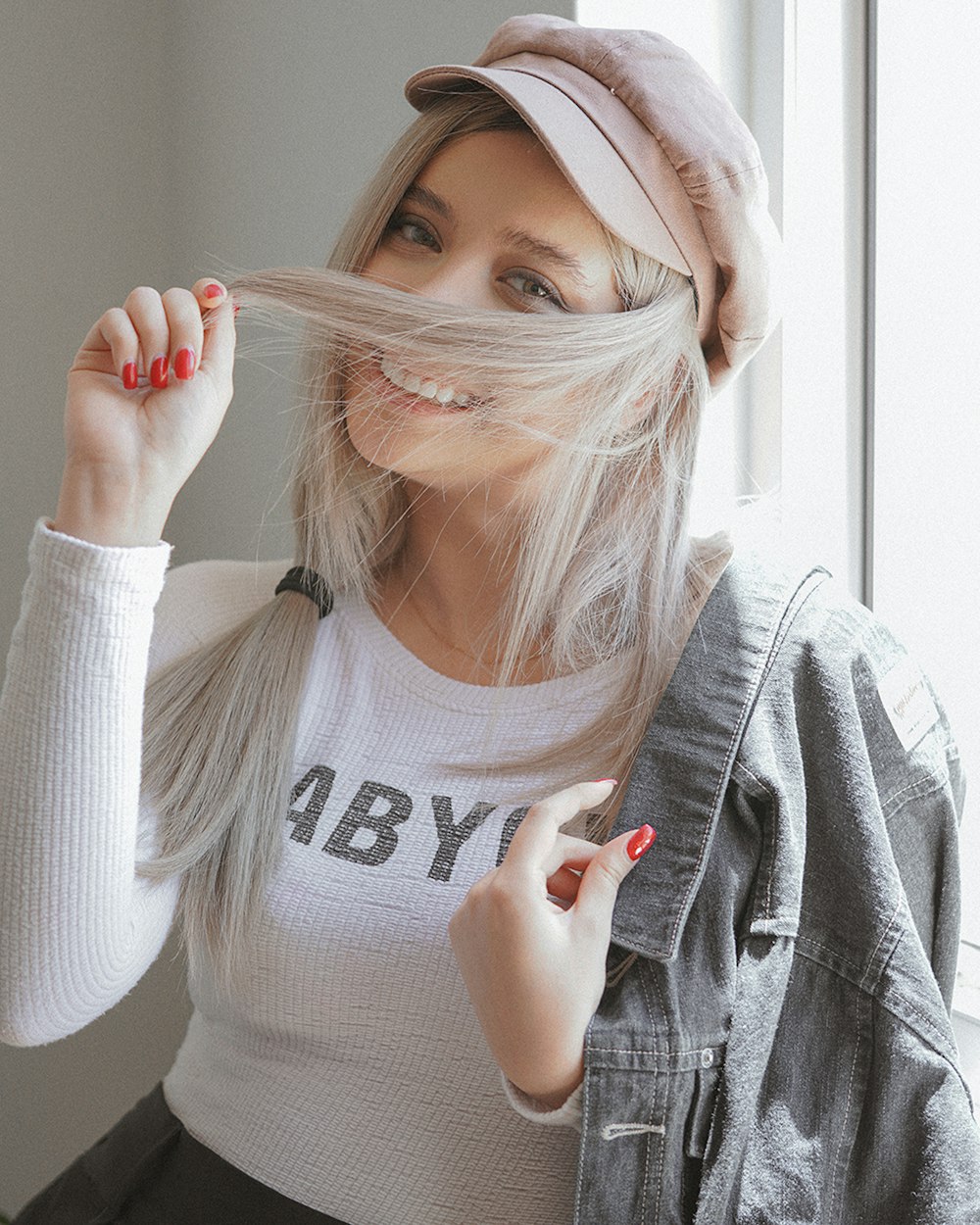woman in gray sweater covering her face with her hand