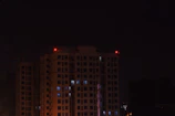 Evening view of a residential building with illuminated emergency lights and fire alarm signs.