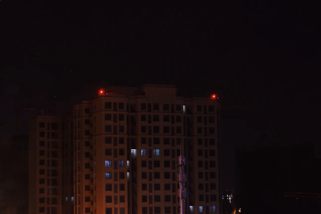 Evening view of a residential building with illuminated emergency lights and fire alarm signs.