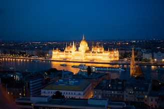 white concrete building near body of water during night time
