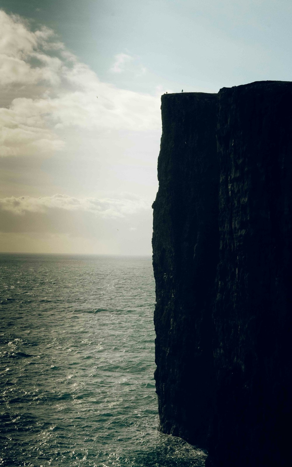 brown rock formation beside sea during daytime