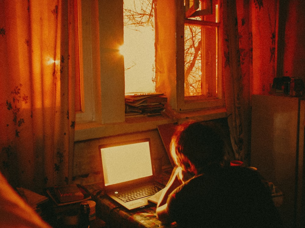 woman sitting on chair using laptop computer