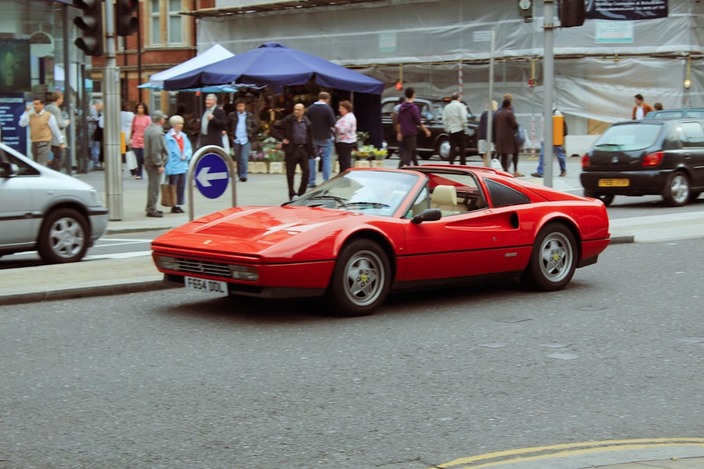 red ferrari coupe on road during daytime