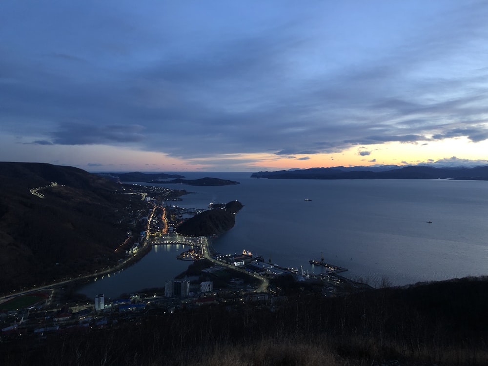 aerial view of city near body of water during sunset