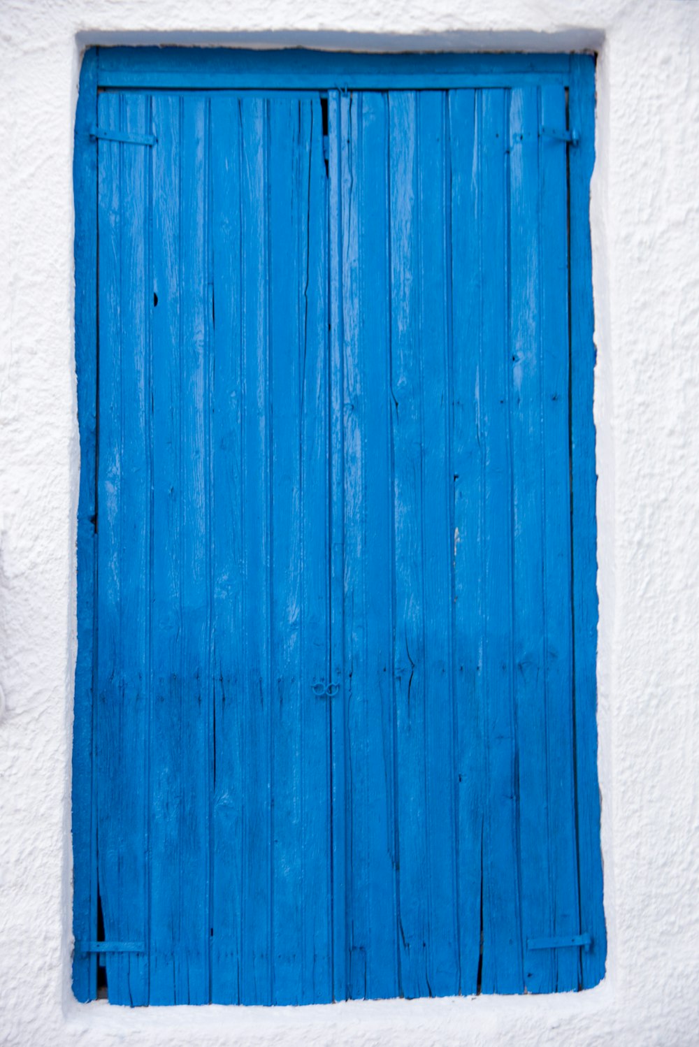 blue wooden door on white concrete wall