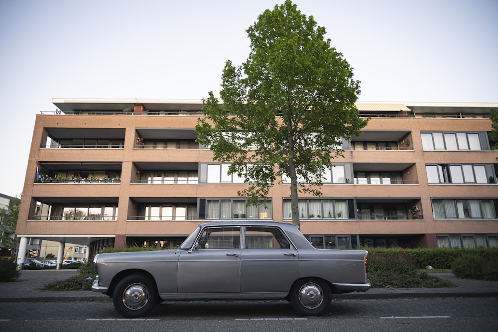 black sedan parked near brown building during daytime