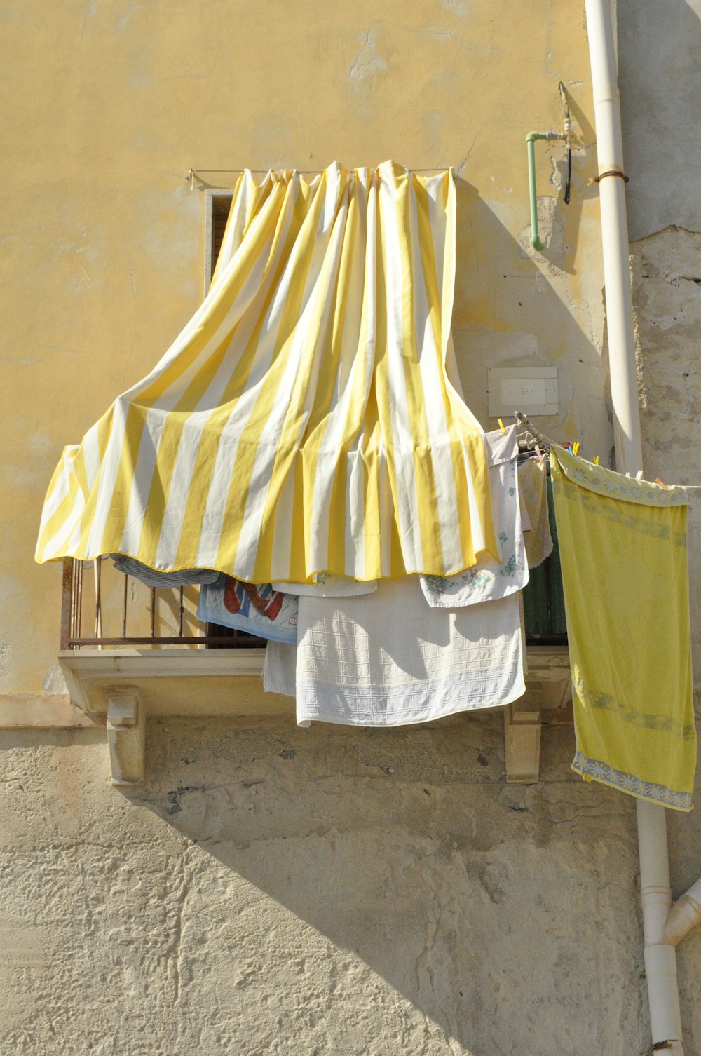 yellow and white textile on brown wooden fence