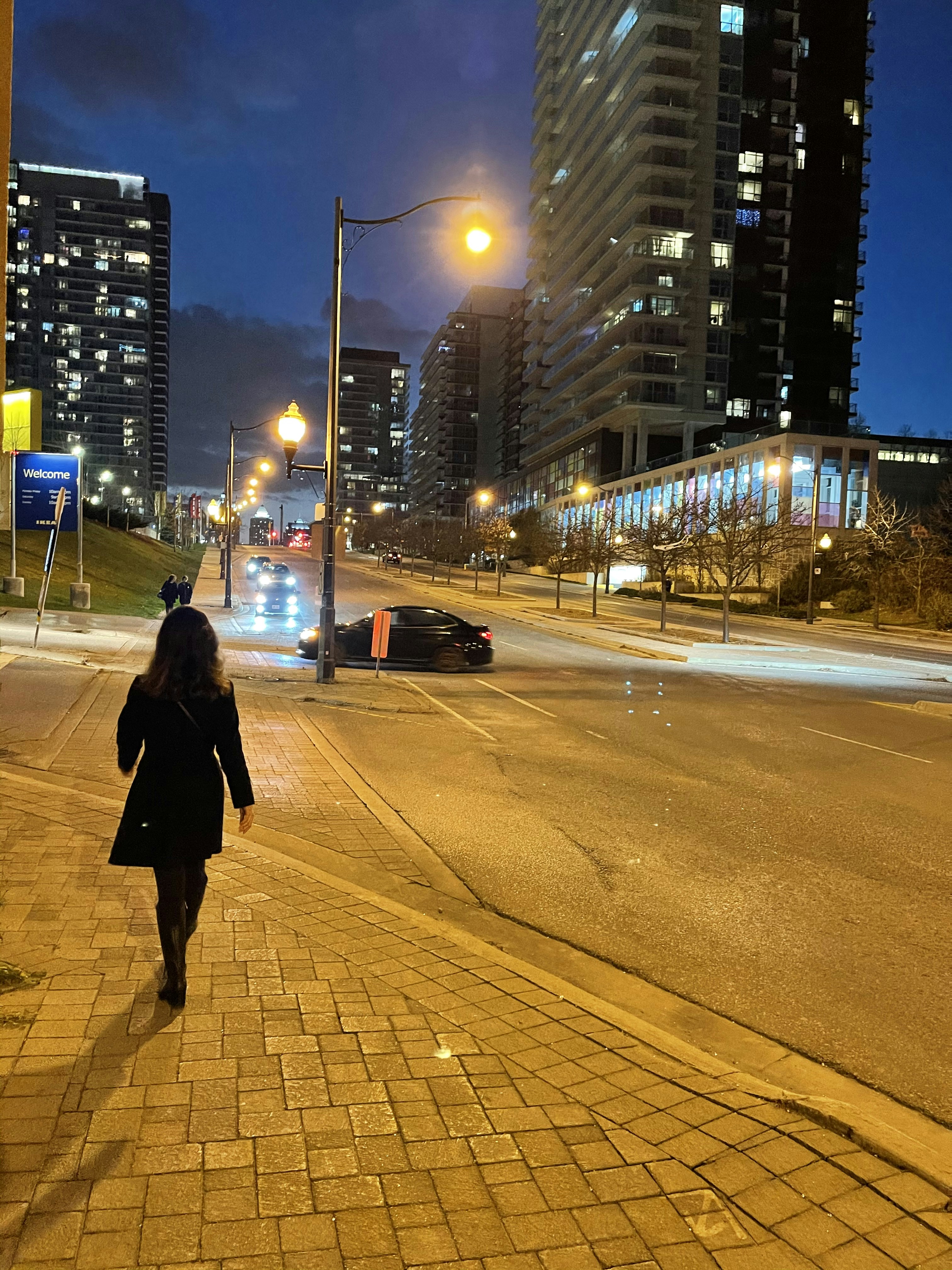 Woman in black coat walking on sidewalk during night time photo – Free ...