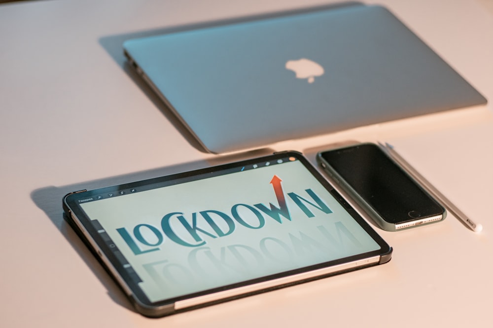 two laptops sitting on top of a table next to each other