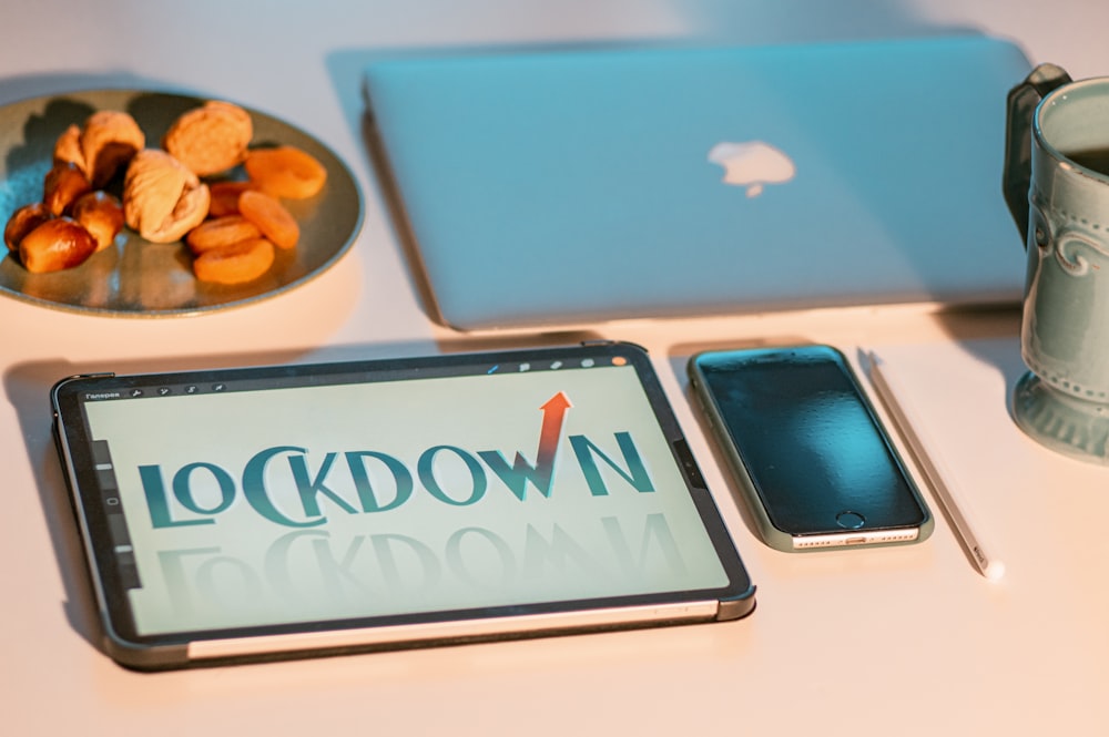 silver macbook beside blue and white ipad case