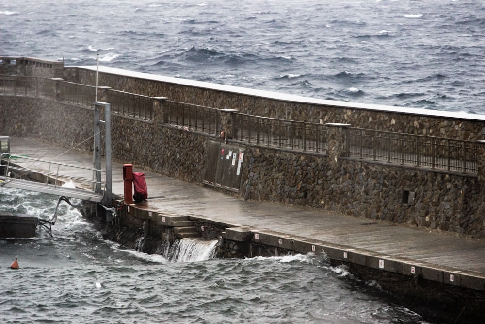 Onde d'acqua che colpiscono il muro di cemento