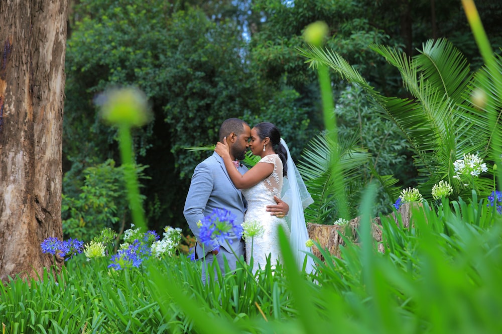 man and woman kissing on purple flower field during daytime