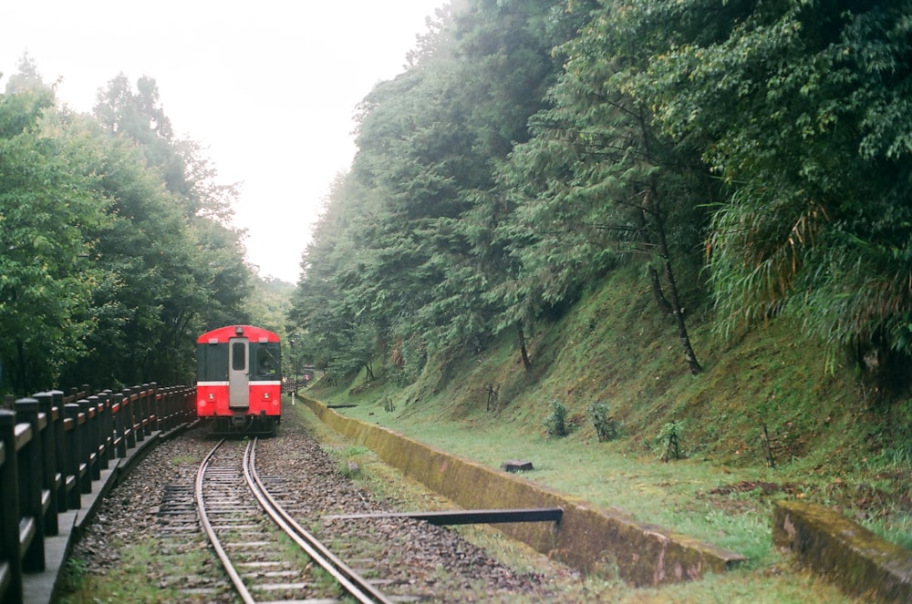 red train on rail tracks during daytime