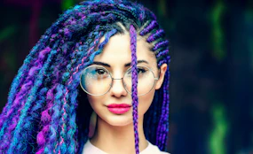 woman with blue hair wearing white tank top and blue framed eyeglasses