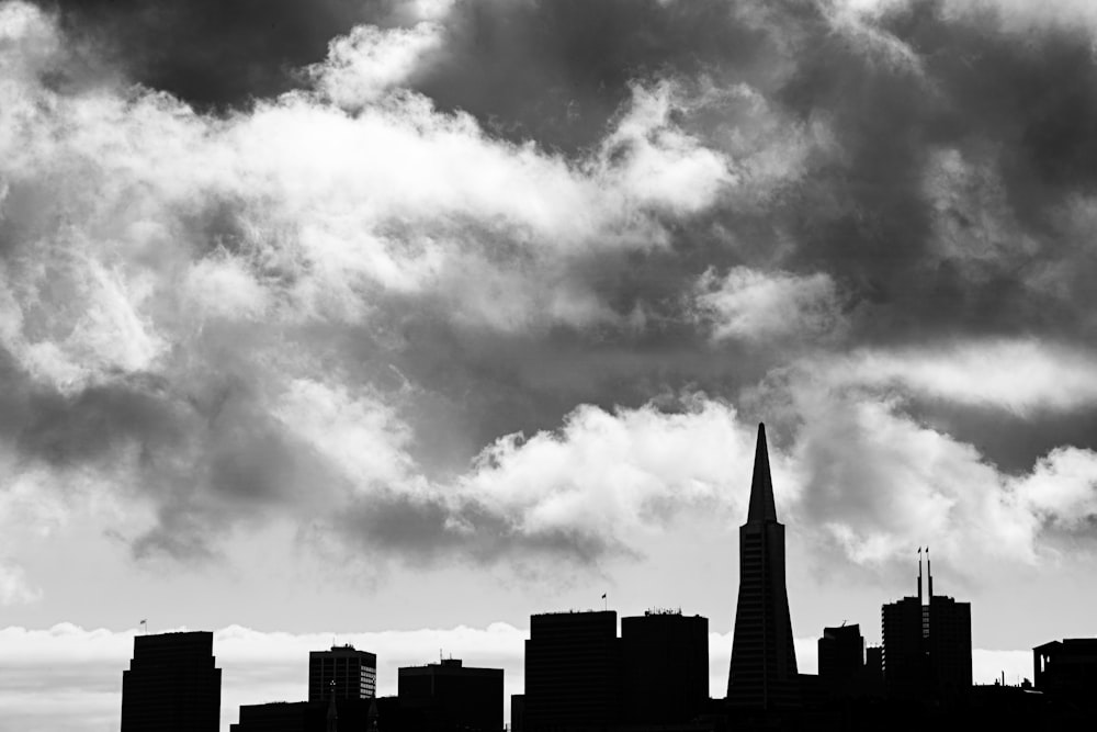 grayscale photo of city buildings under cloudy sky