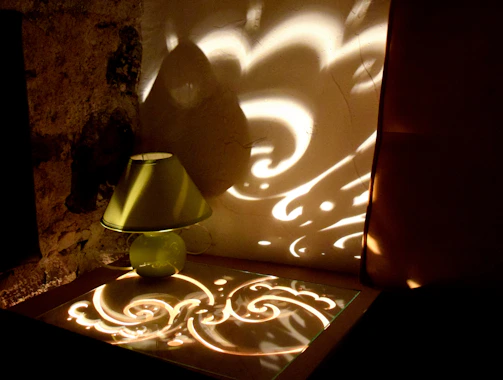 Ambient-lit 3D printed lamp casting intricate shadows on a gray wall.