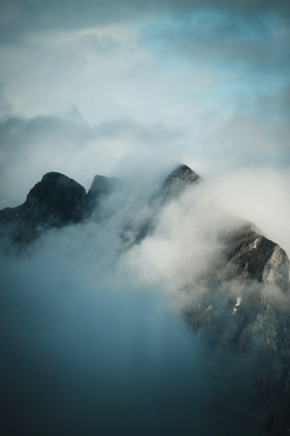 black and white mountain under white clouds