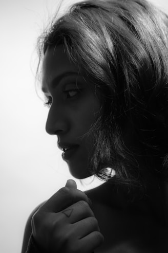 A crisp black and white portrait of a contemplative woman framed by soft morning light.