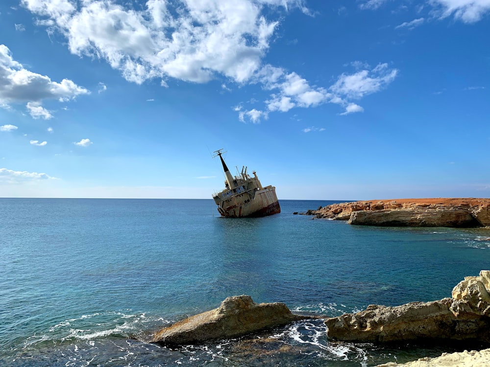 brown ship on sea under blue sky during daytime