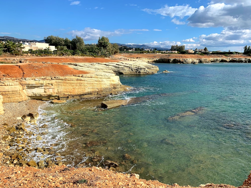 brown rock formation near body of water during daytime