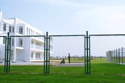 person in black shirt walking on green grass field during daytime