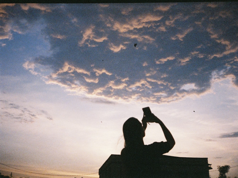 silhouette of man sitting on rock