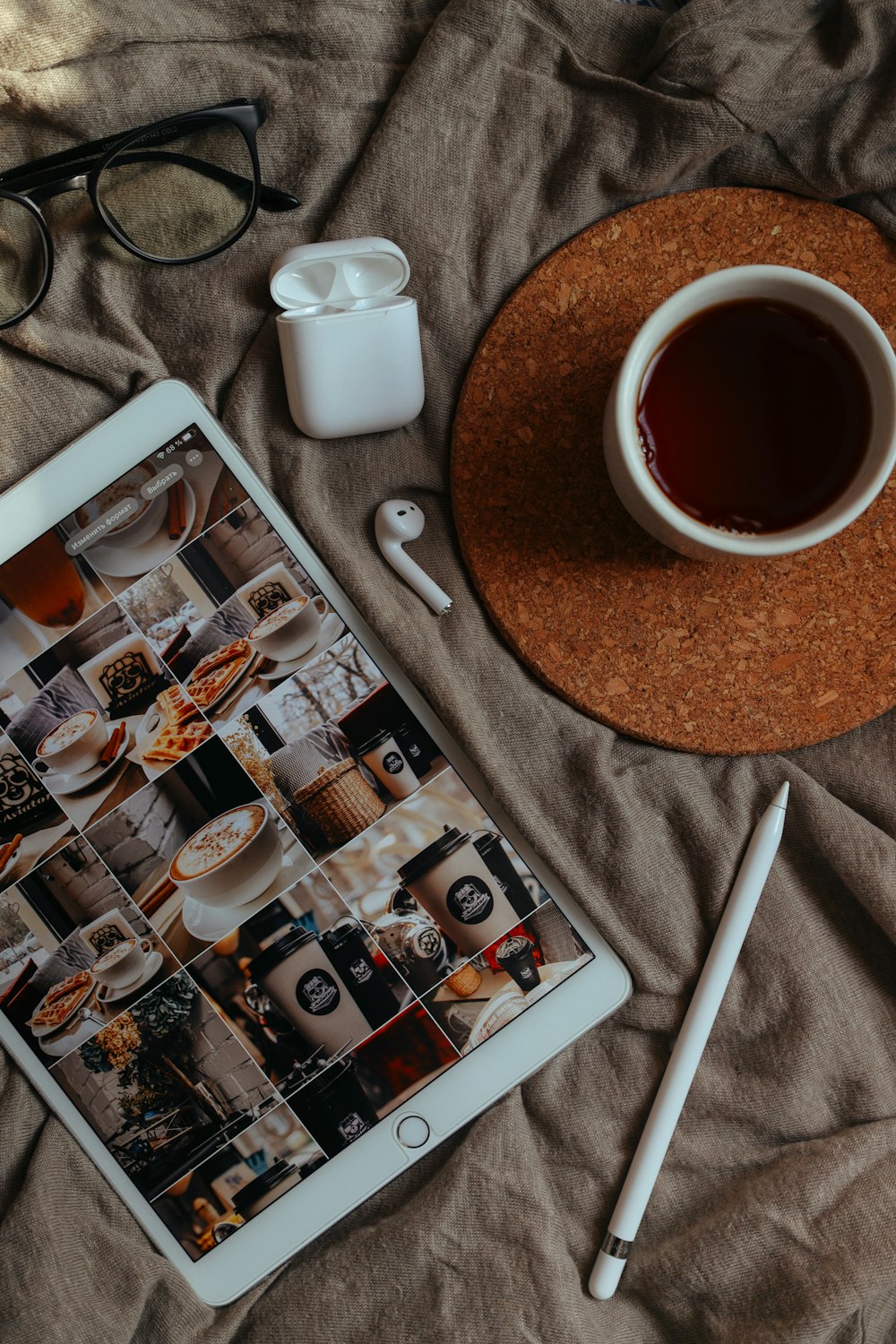 iPad blanco junto a taza de cerámica blanca sobre mesa de madera marrón